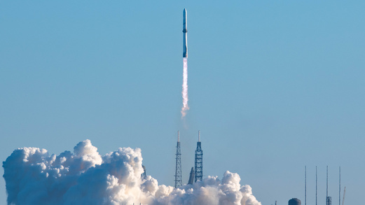 Photo of the Blue Origin New Glenn rocket launching from its pad during the day